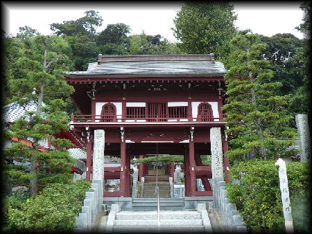 愛染院根本寺：鐘楼門形式の朱色の山門と石造寺号標
