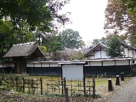 坂野家住宅：板塀越に見える茅葺屋根の主屋