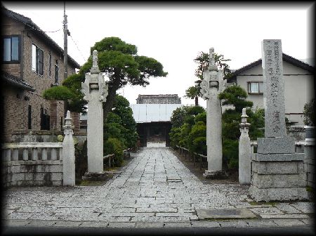 信願寺：境内正面に設けられた石柱山門と石造寺号標